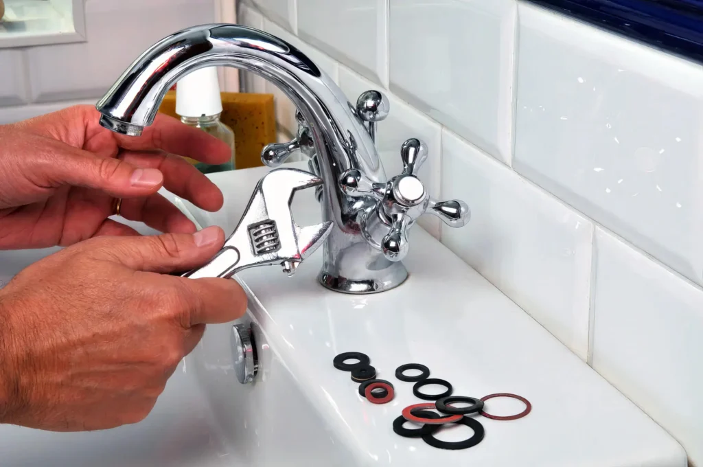 Plumber performing maintenance on a bathroom faucet in New Smyrna Beach