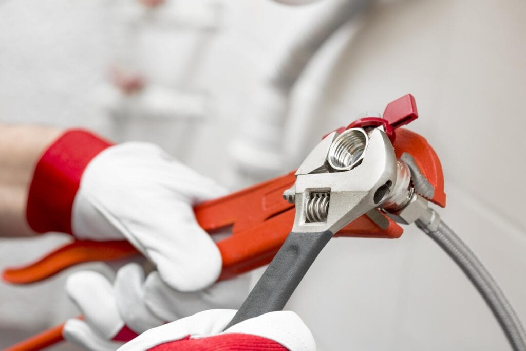 Plumber holding pipe wrenches for an emergency repair in New Smyrna Beach