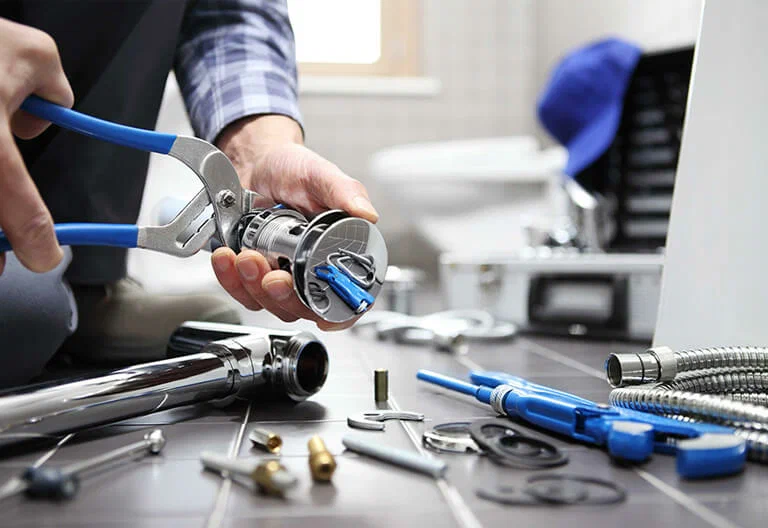 Technician repairing a plumbing fixture with professional tools in New Smyrna Beach