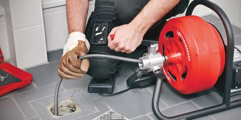 Plumber using a drain-cleaning machine in New Smyrna Beach