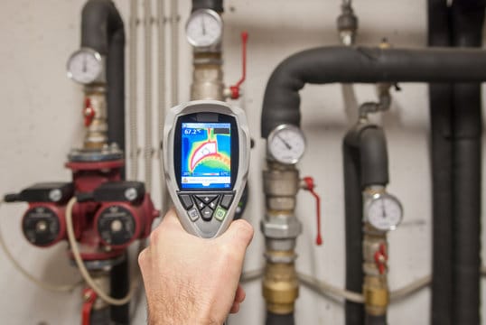 Plumber using a thermal imaging camera to inspect pipes in New Smyrna Beach