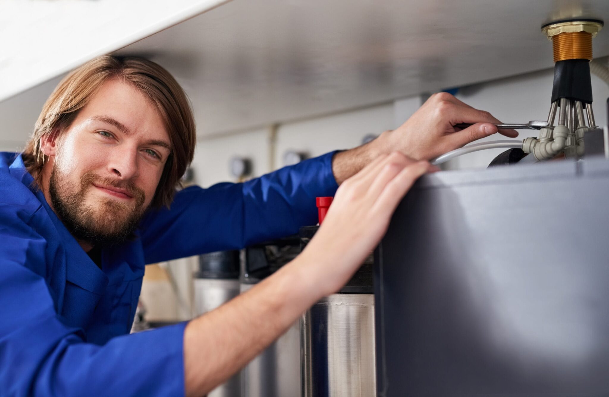 Technician servicing a residential water heater tank in New Smyrna Beach