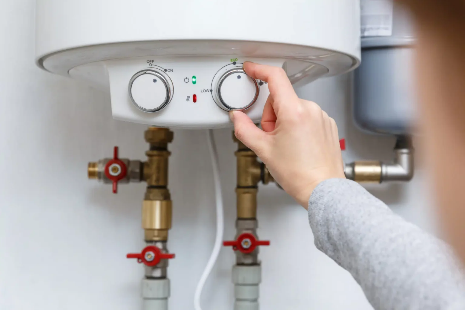 Homeowner adjusting the temperature controls on a water heater in New Smyrna Beach